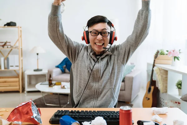 Feliz hombre chino jugando y ganando juego en línea —  Fotos de Stock