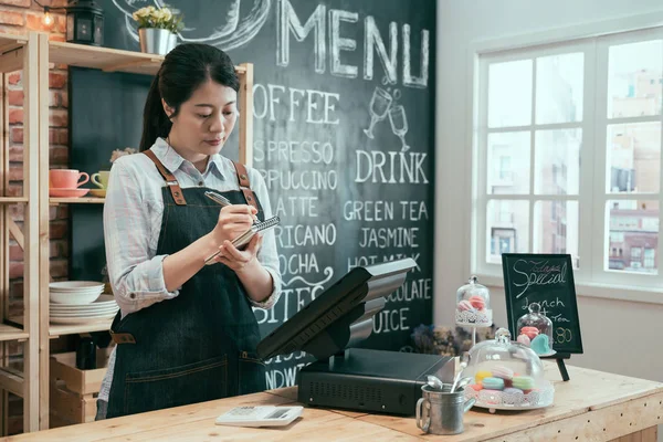 Pretty female barista taking order on notes — Stock Photo, Image