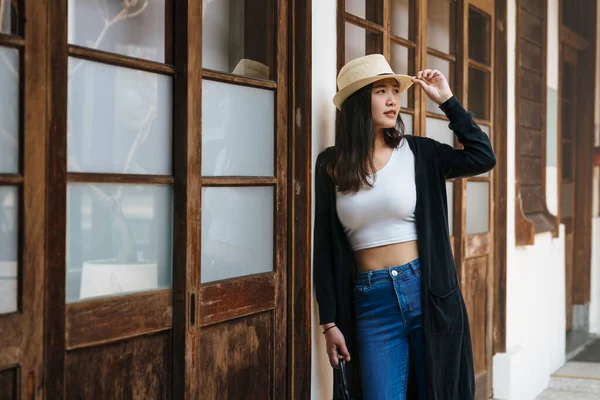 Happy stylish woman leaning against white wall — Stock Photo, Image