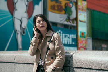 Köprü parmaklıklarına yaslanmış kadın çalışan