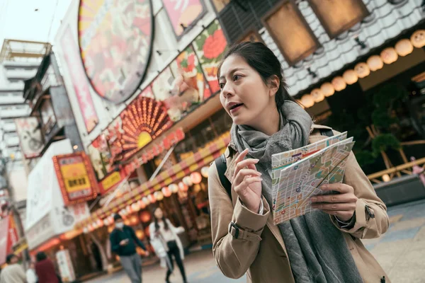 紙の地図を手に街を歩く女性旅行者 — ストック写真