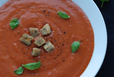 Lezzetli sağlıklı domates ve sebze çorbası ve beyaz tabakta ekmek.