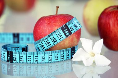 Beyaz çiçekli bant ölçme ile taze kırmızı elma. Görünümü kapatın 