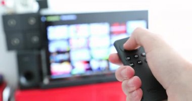 Paris, Fransa, 5 Eylül 2018: Amazon yangın Tv Uzaktan kumanda. Akıllı Tv izlerken ve Modern siyah uzaktan kumanda kullanarak bulanık Tv - 4 k Video