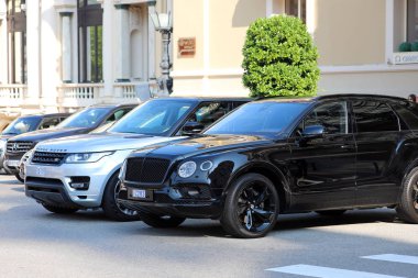 Monte-Carlo, Monaco-19 Eylül 2018: Monte Carlo Casino Monako önünde park etmiş iki lüks SUV: siyah Bentley Bentayga ve gümüş rengi Range Rover