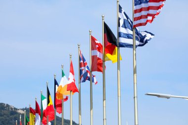 Arka plan mavi gökyüzü ile dizilmiş farklı ülkelerin bayrakları