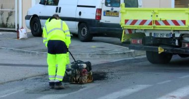 Roquebrune-Cap-Martin, Fransa-5 Aralık 2018: Asfalt yol ile manuel kompaktör plaka, Closeup görünümü - Dci 4 k Video tamiri, işçi