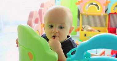 Sevimli genç çocuk içinde renkli çocuk parkı ayakta bebek. Kadar görünüm portre - Dci 4 k çözünürlüklü kapatın