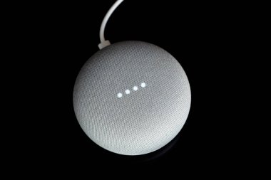 Paris, Fransa - 17 Aralık 2018: Kablo (tebeşir renkli), bir Google Ana sayfa Mini havai görünümü siyah arka plan. Akıllı hoparlör ile Google kalfa, sanal asistan yapay zeka tarafından desteklenmektedir