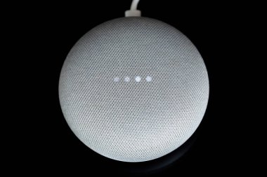 Paris, Fransa - 17 Aralık 2018: Kablo (tebeşir renkli), bir Google Ana sayfa Mini havai görünümü siyah arka plan. Akıllı hoparlör ile Google kalfa, sanal asistan yapay zeka tarafından desteklenmektedir 