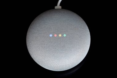 Paris, Fransa - 17 Aralık 2018: Kablo (tebeşir renkli), bir Google Ana sayfa Mini havai görünümü siyah arka plan. Akıllı hoparlör ile Google kalfa, sanal asistan yapay zeka tarafından desteklenmektedir