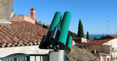 Turist sikke dürbün bir bakış açısı Roquebrune-Cap-Martin, eski Fransız ortaçağ köyü mavi gökyüzünde yamaç paraşütü, Akdeniz French Riviera, Fransa, Avrupa - Dci 4 k Video ile işletilen
