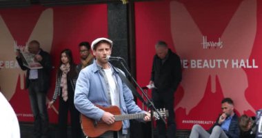 Londra, İngiltere, 29 Mayıs 2019: Man Playing A Guitar Ve Singing Into A Microphone In The Street In Harrods Alışveriş Merkezi, Londra - Close Up View - Dci 4k Çözünürlük