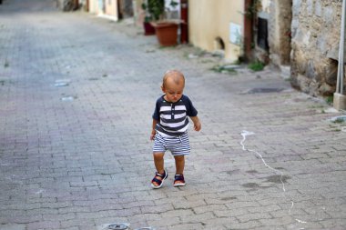 Baby Boy Walking Alone In The Street clipart