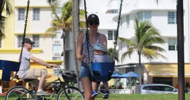 Miami, Florida / Abd, Şubat 24, 2019: Genç Güzel Kadın Miami Beach Bir Parkta Bir Salıncak Bir Baby Boy Push (South Beach), Florida, Amerika Birleşik Devletleri. Yakın Çekim Görünümü - Dci 4k Çözünürlük