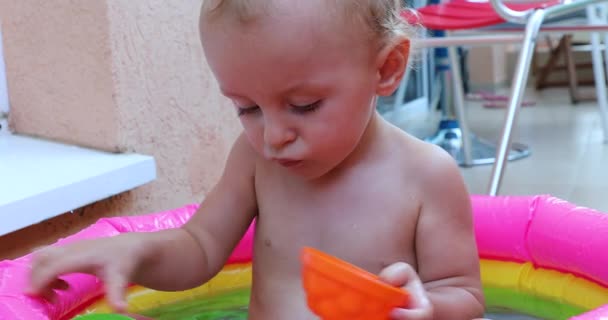 Lindo Bebé Jugando Con Juguetes Una Colorida Mini Piscina Vista — Vídeos de Stock