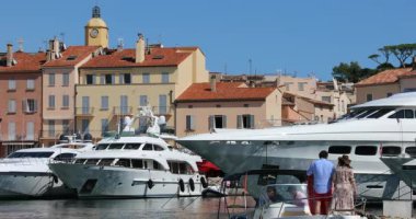 Saint-Tropez, Fransa - 7 Eylül 2019: Lüks Yatlar ve Renkli Evler, Fransız Rivierası 'ndaki Saint Tropez Limanı' nın Kilise Kulesi, Var, Fransa, Avrupa - Dci 4k Video