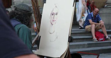 Florence, Italy - August 31, 2019: Street Male Artist Drawing A Portrait Of A Young Woman With Pastels And An Easel In Florence, Italy, Tuscany Region, Europe. Close Up View - DCi 4K Video
