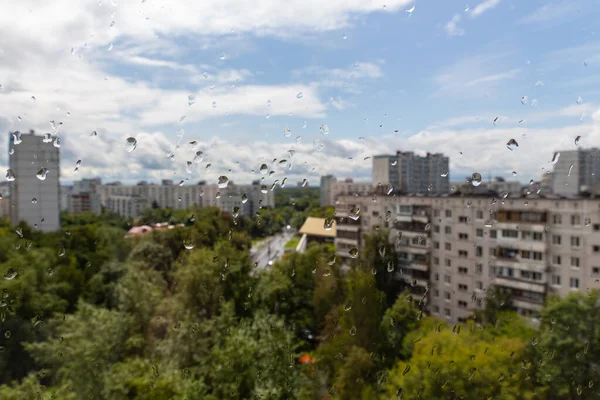 街の建物や空を背景に窓ガラスに水が落ちる 美しい雨滴 雨の天気 モスクワの都市景観 — ストック写真
