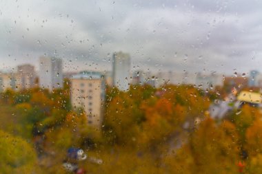 Moskova 'da (Rusya) sonbaharda bulutlu yağmurlu bir gün. Ani soğuk çarpması, cam ve şehir manzarasına damlalar. Islak cam dokusu.