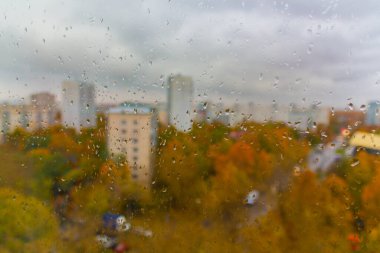 Moskova 'da (Rusya) sonbaharda bulutlu yağmurlu bir gün. Ani soğuk çarpması, cam ve şehir manzarasına damlalar. Islak cam dokusu.