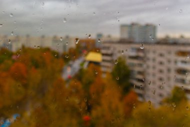 Moskova 'da (Rusya) sonbaharda bulutlu yağmurlu bir gün. Ani soğuk çarpması, cam ve şehir manzarasına damlalar. Islak cam dokusu.