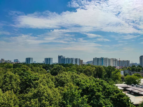 Stadsgezicht Van Een Hoogbouw Een Park Met Witte Pluizige Wolken — Stockfoto