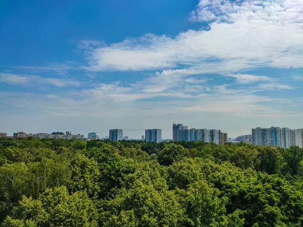 Stadsgezicht Van Een Hoogbouw Een Park Met Witte Pluizige Wolken — Stockfoto