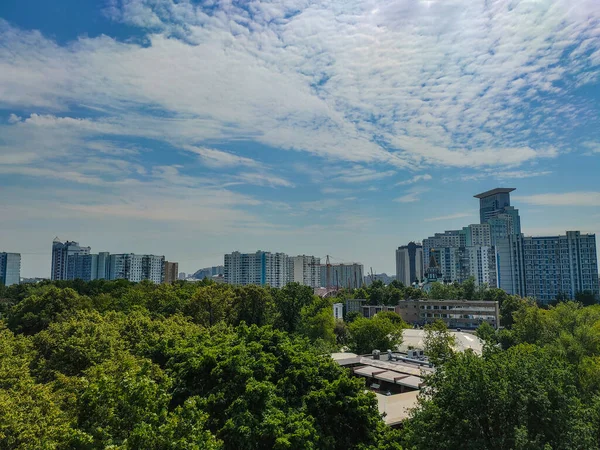 Yüksek Katlı Bir Binanın Beyaz Kabarık Bulutlu Bir Parkın Manzarası — Stok fotoğraf