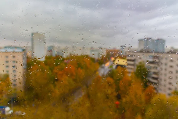 Moskova 'da (Rusya) sonbaharda bulutlu yağmurlu bir gün. Ani soğuk çarpması, cam ve şehir manzarasına damlalar. Islak cam dokusu.