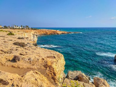 Kayalık kayalıkları ve mağaralara yakın mavi suları olan Rocky plajı ve sevgililer köprüsü, Kıbrıs Rum Kesimi, Ayia Napa. Akdeniz manzarası.