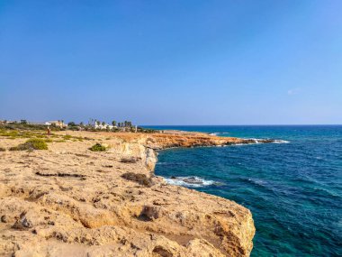 Kayalık kayalıkları ve mağaralara yakın mavi suları olan Rocky plajı ve sevgililer köprüsü, Kıbrıs Rum Kesimi, Ayia Napa. Akdeniz manzarası.