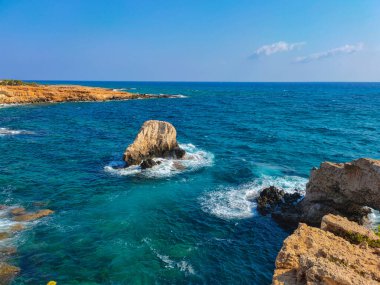 Kayalık kayalıkları ve mağaralara yakın mavi suları olan Rocky plajı ve sevgililer köprüsü, Kıbrıs Rum Kesimi, Ayia Napa. Akdeniz manzarası.