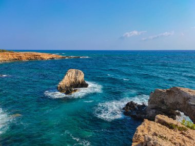 Kayalık kayalıkları ve mağaralara yakın mavi suları olan Rocky plajı ve sevgililer köprüsü, Kıbrıs Rum Kesimi, Ayia Napa. Akdeniz manzarası.