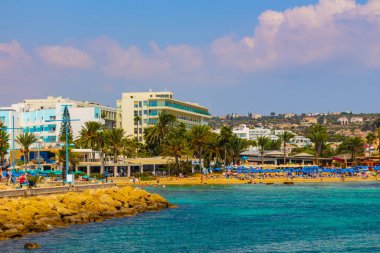 Ayia Napa, Kıbrıs - 06 Eylül 2019: Ayia Napa Limanı. Balıkçı tekneleri, palmiyeler ve turistler.