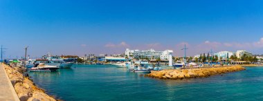 Ayia Napa, Kıbrıs - Eylül 06, 2019: Ayia Napa Limanı Panoraması. Balıkçı tekneleri, palmiyeler ve turistler.
