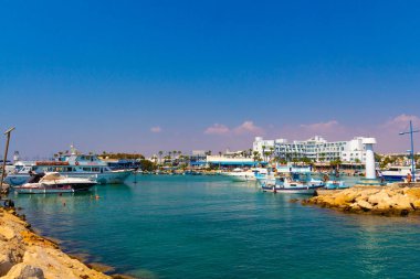 Ayia Napa, Kıbrıs - 06 Eylül 2019: Ayia Napa Limanı. Balıkçı tekneleri, palmiyeler ve turistler.