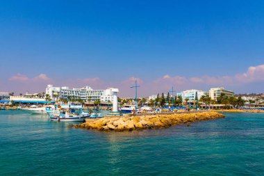 Ayia Napa, Kıbrıs - 06 Eylül 2019: Ayia Napa Limanı. Balıkçı tekneleri, palmiyeler ve turistler.