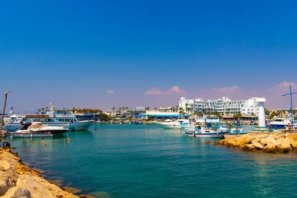 Ayia Napa, Kıbrıs - 06 Eylül 2019: Ayia Napa Limanı. Balıkçı tekneleri, palmiyeler ve turistler.