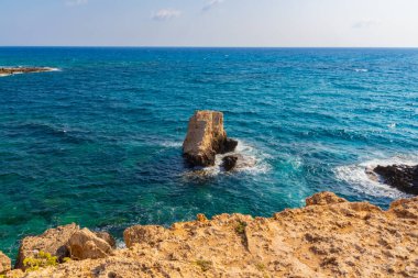 Kayalık kayalıkları ve mağaralara yakın mavi suları olan Rocky plajı ve sevgililer köprüsü, Kıbrıs Rum Kesimi, Ayia Napa. Akdeniz manzarası.