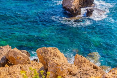 Kayalık kayalıkları ve mağaralara yakın mavi suları olan Rocky plajı ve sevgililer köprüsü, Kıbrıs Rum Kesimi, Ayia Napa. Akdeniz manzarası.