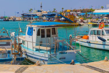 Ayia Napa, Kıbrıs - 07 Eylül 2019: Ayia Napa Limanı. Balıkçı tekneleri, palmiyeler ve turistler.
