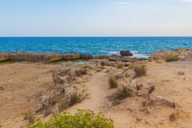 Kıbrıs Rum Kesimi 'nin Ayia Napa kentindeki Akdeniz' in Rocky plajı. Doğal taş oluşumları.