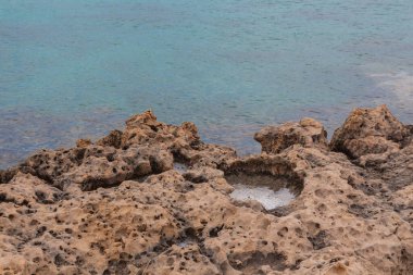 Kıbrıs Rum Kesimi 'nin Ayia Napa kentindeki Akdeniz' in Rocky plajı. Doğal taş oluşumları.