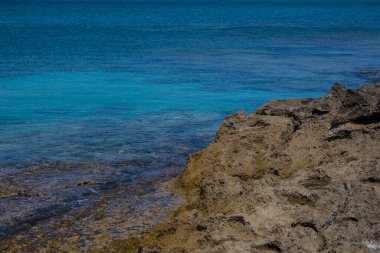 Kayalık bir sahilde şeffaf deniz dalgaları. Protaras, Kıbrıs. Protaras ağırlıklı olarak turizm merkezidir..