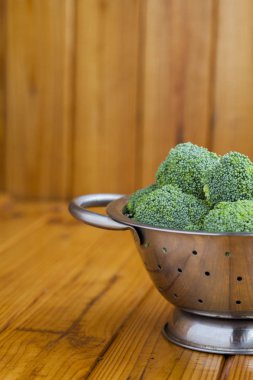 Lahana brokoli ahşap bir masa üzerinde bir kevgir içinde