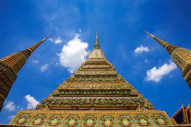 Wat Pho ya da Wat Phra Chetuphon, Bangkok, Tayland 'daki üç pagoda alçak açılı görünüyor..