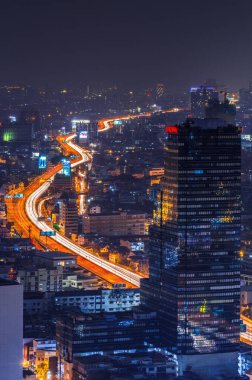 Bangkok, Tayland 'daki kamu binaları arasında ekspres yoldaki ışık yolları.