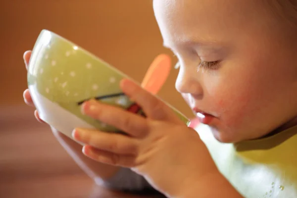 Kleine jongen zelfstandig drinken uit een kom — Stockfoto