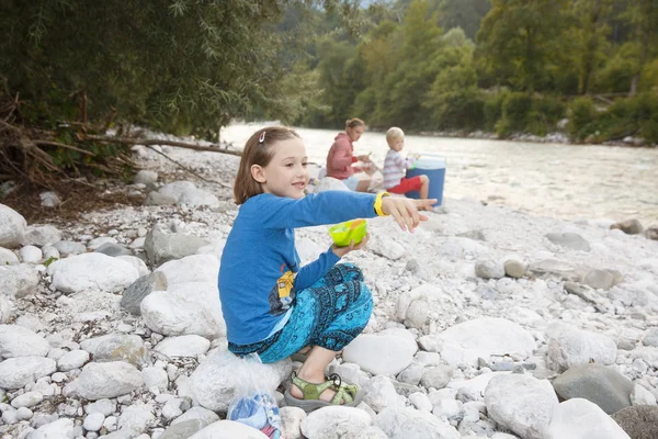 Menina comendo na natureza, fazendo piquenique com sua família. Estilo de vida ao ar livre, parentalidade positiva, conceito de experiência infantil . — Fotografia de Stock